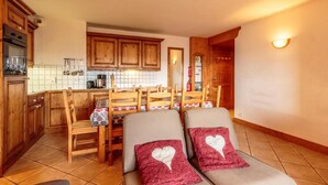 Una cocina acogedora con armarios de madera y un comedor con cuatro sillas.