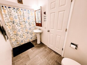 Tina con regadera, secadora de cabello, toallas, jabón 