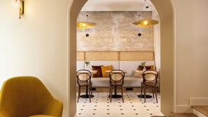 A modern interior with a sofa set, two chairs, and a table in a hallway with an arched doorway. - Alberte Hotel (Paris)