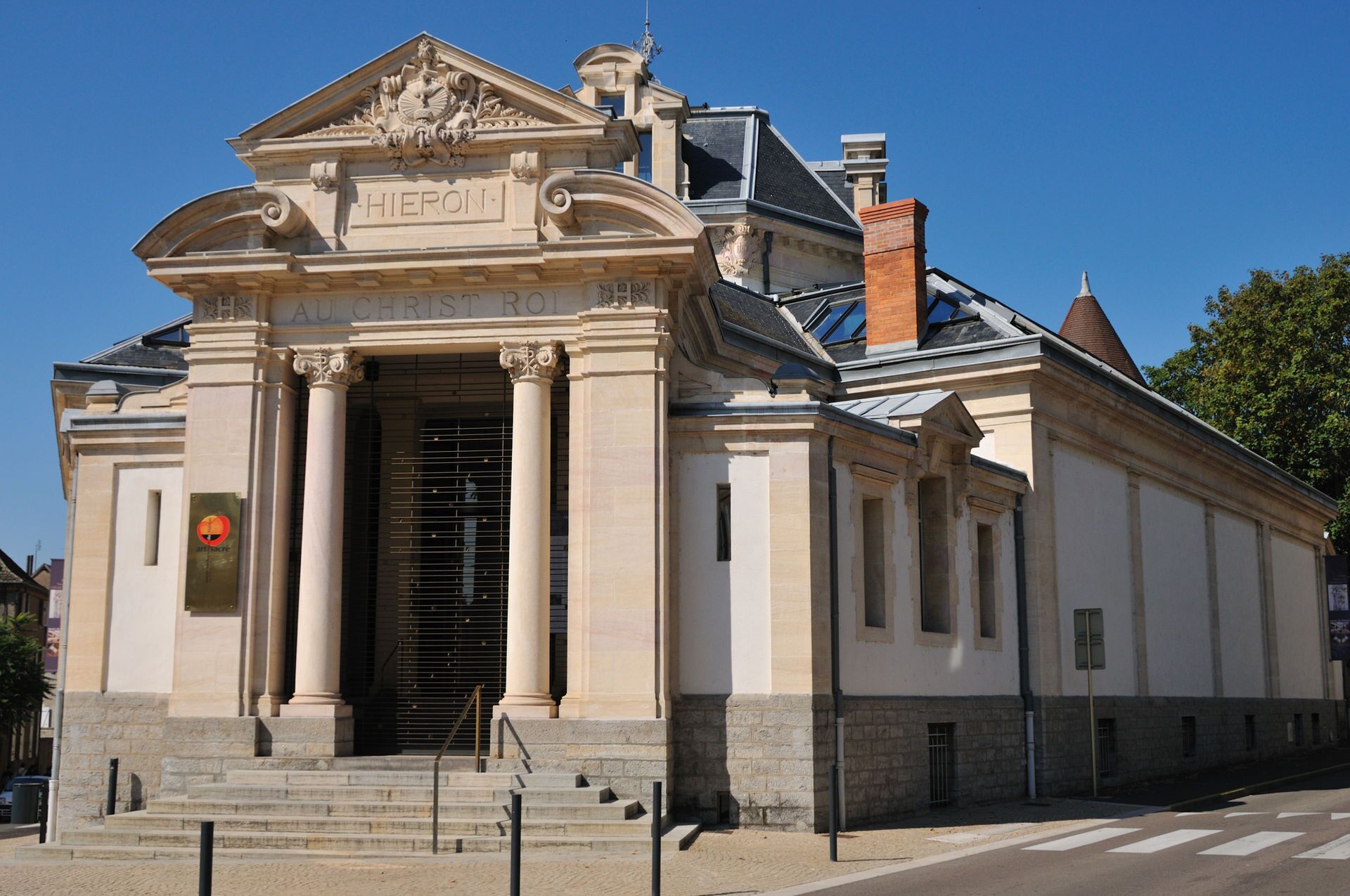 A classical building with a prominent entrance, columns, and a clock.