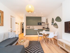 En moderne lejlighed med opholdsstue, spiseområde og køkken.