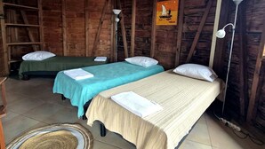 A rustic cabin with two beds, a wooden ceiling, and a tiled floor. - Baobab 3 Vacation Rental – Tropical Charm & Ocean-View Pool (Sainte-Anne)