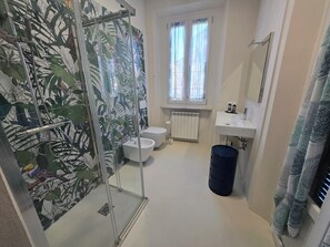 Een douche, een haardroger, een bidet, handdoeken