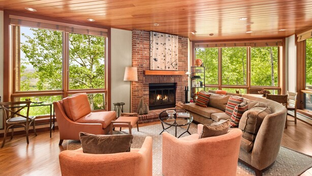 A spacious living room with a fireplace, large windows, and a cozy seating area.