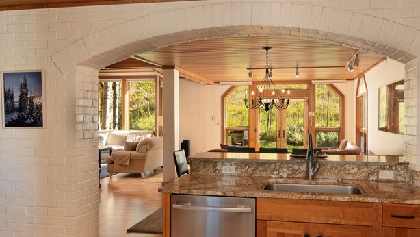 A kitchen with granite countertops, wooden cabinets, and a stainless steel dishwasher.