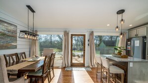 Una cucina moderna con zona pranzo, pavimento in legno e vista sul giardino.
