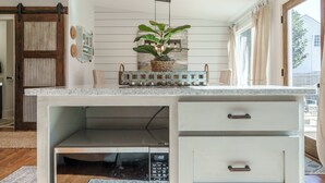 Una cucina con forno a microonde integrato, lavello e piano di lavoro.
