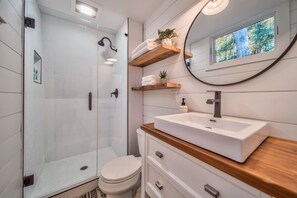 Een douche, handdoeken, shampoo, toiletpapier