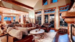 A spacious living room with a large sofa, a coffee table, and a fireplace. - Book 3+4th FREE Amazing views, Hot Tub, Pool Table, Hot Springs, Moose sightings (Fairplay)