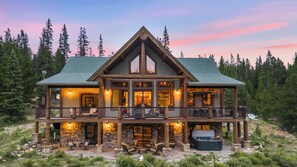 A large lodge with a stone facade, multiple balconies, and a fire pit area.