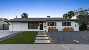 Ein modernes Einfamilienhaus mit Garage, Rasen und Kiesweg.