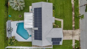 Una casa moderna con piscina, paneles solares y un césped bien cuidado.
