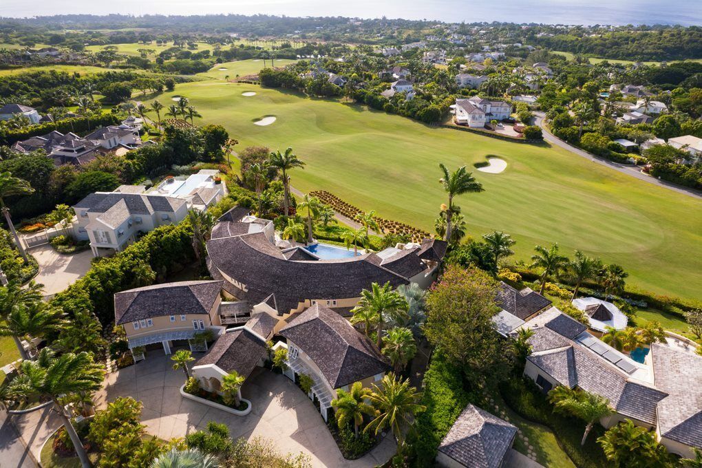 A golf course with a clubhouse and residential buildings.