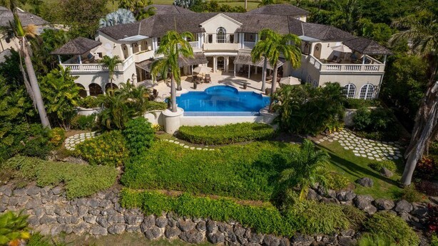A large house with a swimming pool, surrounded by tropical vegetation and palm trees. - Wild Cane Ridge 2 by Island Villas (Westmoreland)