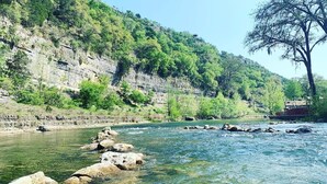 Un río de aguas cristalinas, rodeado de terreno rocoso y vegetación.