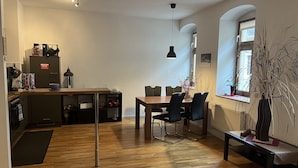 Una cocina moderna con armarios de madera, una mesa de comedor y sillas. Hay una ventana con vistas al exterior.