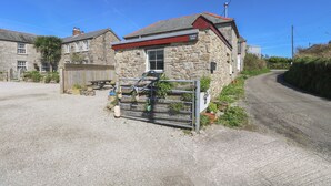 A stone building with a red roof and a sign that reads "Lanch Barn." - Larch Barn (Helston)