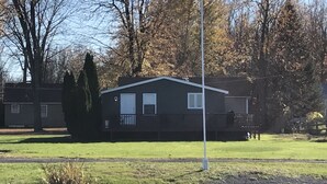 A single-story building with a flat roof, a small porch, and a flagpole in front.