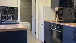 A modern kitchen with a central island, a built-in oven, and a refrigerator.