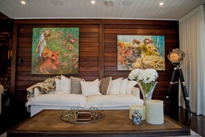 Relax in this stylish living room with a sofa, coffee table, and artistic touches.