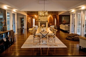Enjoy dining and relaxation in this elegantly furnished room with a long table, fireplace, and comfortable seating.