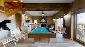 Relax in this inviting space with a pool table, comfortable seating, and a cozy fireplace.