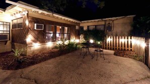 A house with a covered patio, a fenced backyard, and outdoor lighting. - The Hoggtown Hideaway (Gainesville)
