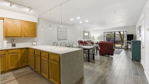 A modern kitchen with wooden cabinets, a granite island, and recessed lighting. - 2 bedroom, 2 bath ground floor condo with indoor pool minutes from Branson strip (Branson)