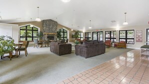 A spacious lobby with a stone fireplace, comfortable seating, and large windows offering views of the outdoors. - 2 bedroom, 2 bath ground floor condo with indoor pool minutes from Branson strip (Branson)