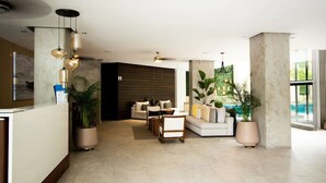 A modern lobby with a reception desk, seating area, and large windows. - Condominios Z (Puerto Vallarta)