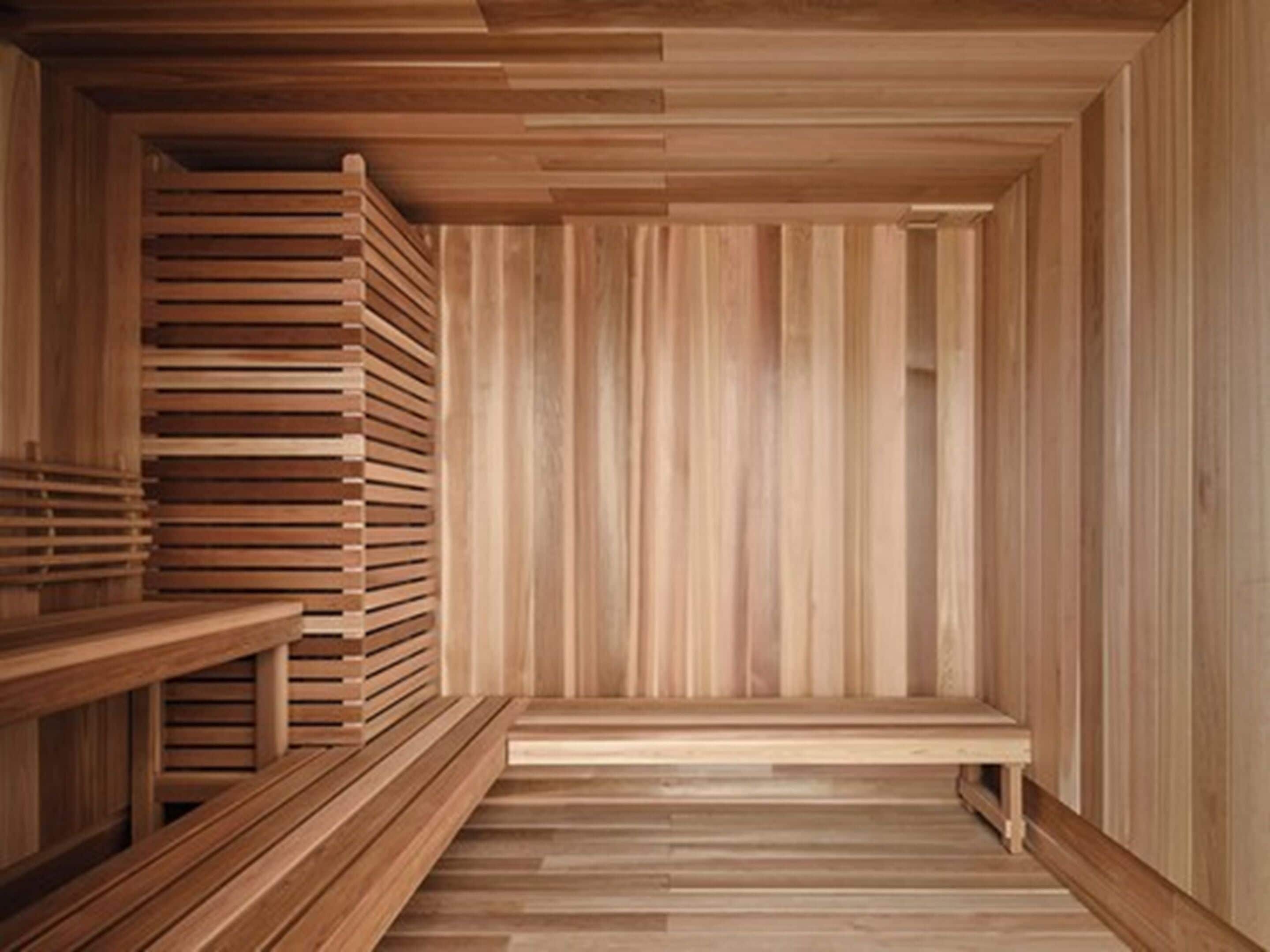 A wooden sauna with benches and a slatted wall design.