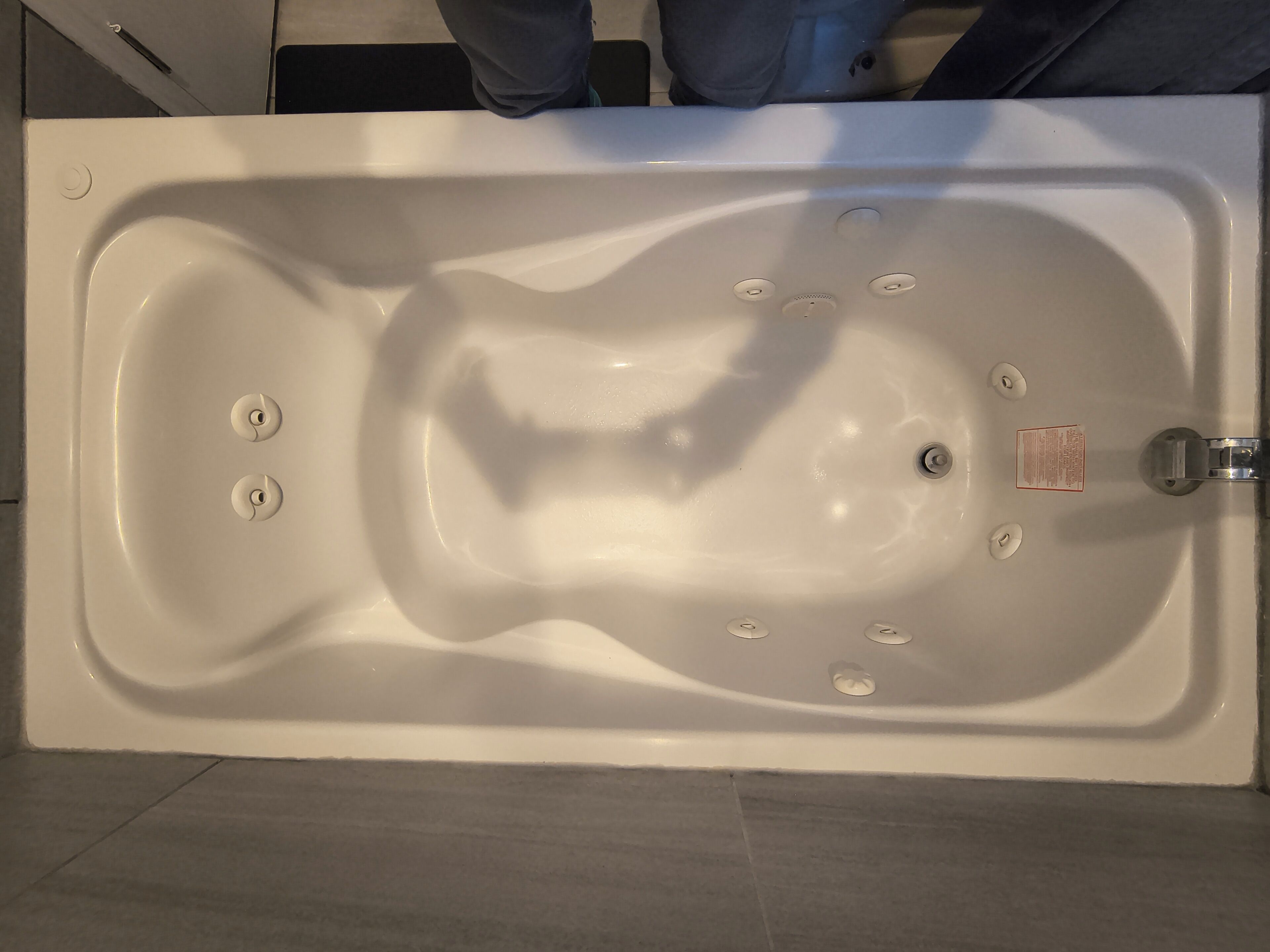 A white bathtub with a faucet and a control panel.