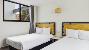 A hotel room with two beds, a window with curtains, a wooden headboard, and a small wooden shelf. - Lago Zirahuén By HomiRent (Mexico City)