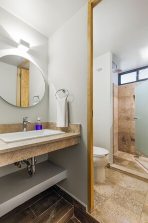 Une salle de bain moderne avec un lavabo, un miroir et des toilettes.