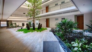 A multi-level atrium with a central garden area, multiple balconies, and a modern architectural design. - Condominios AR (Puerto Vallarta)