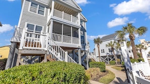 A multi-story beachfront house with a balcony, a covered porch, and a staircase leading to the upper levels. - "Siren's Song" Oceanfront Beach House w/pool (Murrells Inlet)