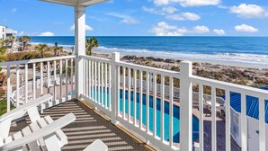 A balcony with a pool, white railings, and a view of the ocean and beach. - "Siren's Song" Oceanfront Beach House w/pool (Murrells Inlet)