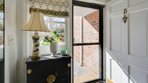 A room with a black cabinet, a lamp, a vase with flowers, and a door with a 'B' sign. - 4 Mi to Dtwn: Spacious Suite in Mount Airy (Mt Airy)