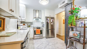 A modern kitchen with white cabinetry, stainless steel appliances, and a marble floor. - 4 Mi to Dtwn: Spacious Suite in Mount Airy (Mt Airy)