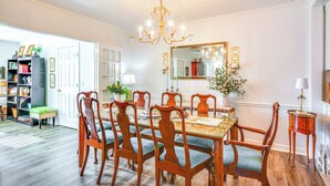 A dining room with a wooden table and chairs, a chandelier, and a large mirror on the wall. - 4 Mi to Dtwn: Spacious Suite in Mount Airy (Mt Airy)