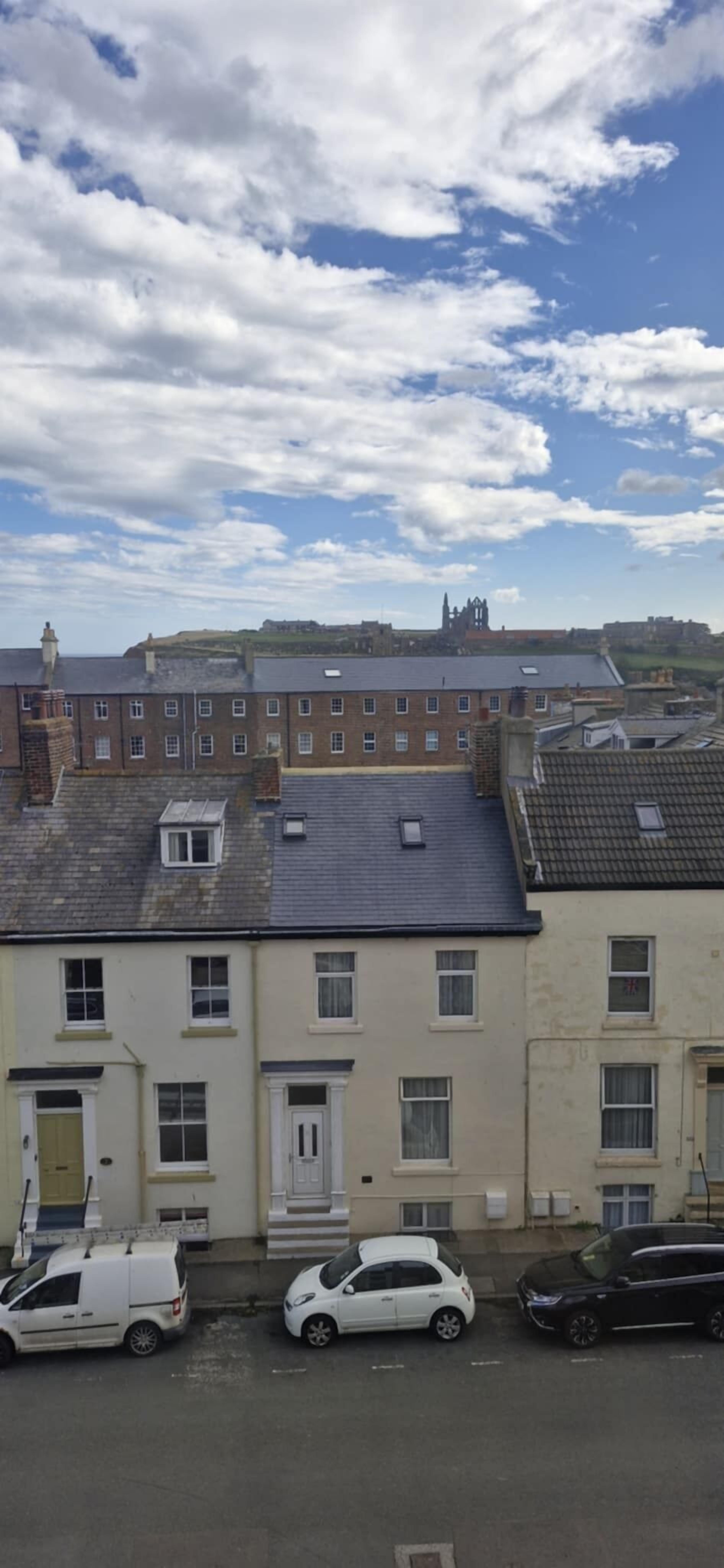 Una hilera de casas adosadas con vistas a un castillo en la distancia.