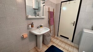 Un bagno con lavandino, specchio, asciugamano e doccia.