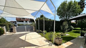 A covered patio area with a view of a house in the background. - Apartments Cocolo - Superior One Bedroom Apartment with Terrace (Porec)