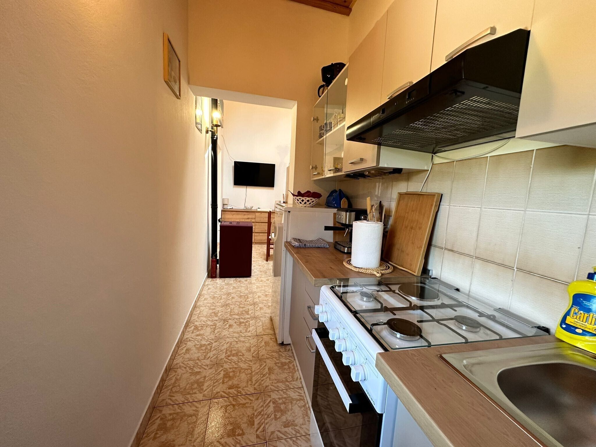 A compact kitchen with a gas stove, a microwave, and a sink.