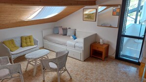 A cozy room with a bed, a sofa, and a dining table. - Apartments Cocolo - Superior One Bedroom Apartment with Terrace (Porec)