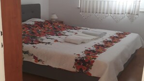 A bedroom with a bed, a nightstand, a lamp, and a window with curtains. - Apartments Semafor - One Bedroom Apartment with Terrace A1 (Seget Vranjica)