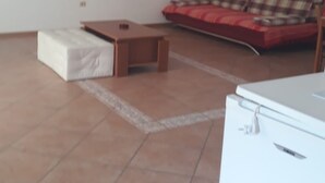 A living room with a sofa, a small table, a white cabinet, and a white appliance. - Apartments Semafor - One Bedroom Apartment with Terrace A1 (Seget Vranjica)