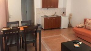 A compact living space with a dining area, kitchenette, and a sofa. - Apartments Semafor - One Bedroom Apartment with Terrace and Sea View A3 (Seget Vranjica)