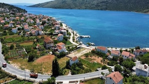A coastal village with houses, a road, and a clear view of the sea. - Apartments Semafor - One Bedroom Apartment with Terrace and Sea View A4 (Seget Vranjica)