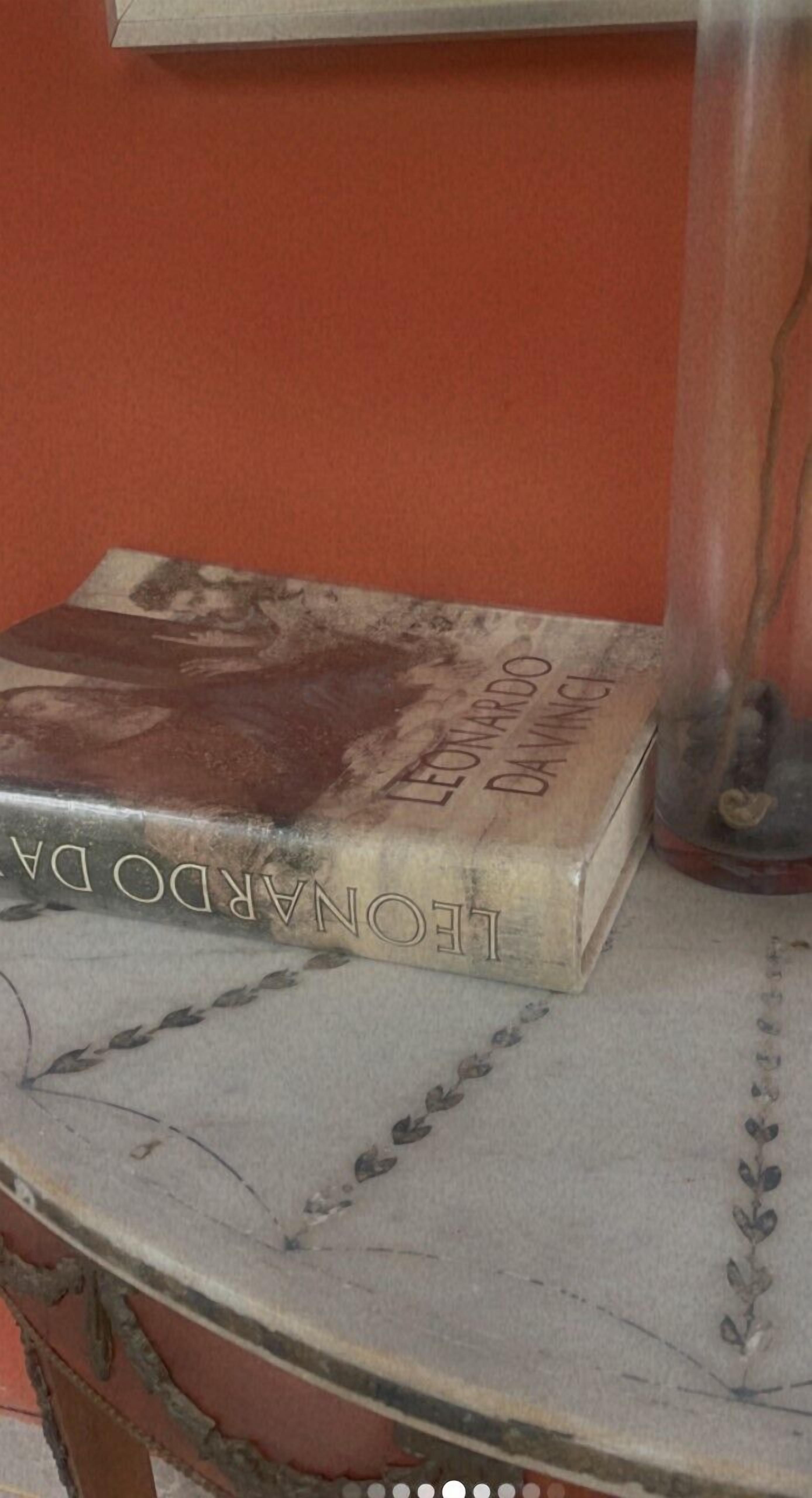 A book titled 'Leonardo da Vinci' on a marble table with a decorative border.